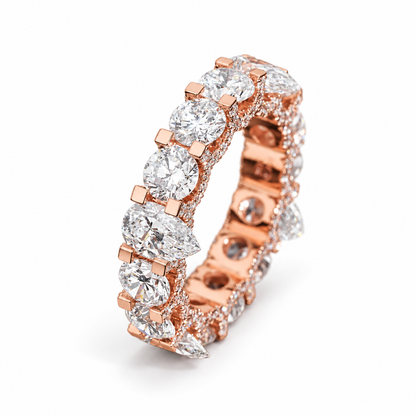 A rose gold eternity ring featuring marquise-cut and round brilliant-cut diamonds, set in a polished rose gold band with pavé diamonds, photographed on a clean white background.