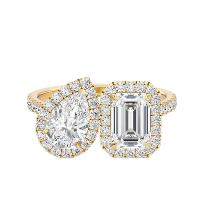 Two diamond rings with gold and emerald cut stones on a white background
