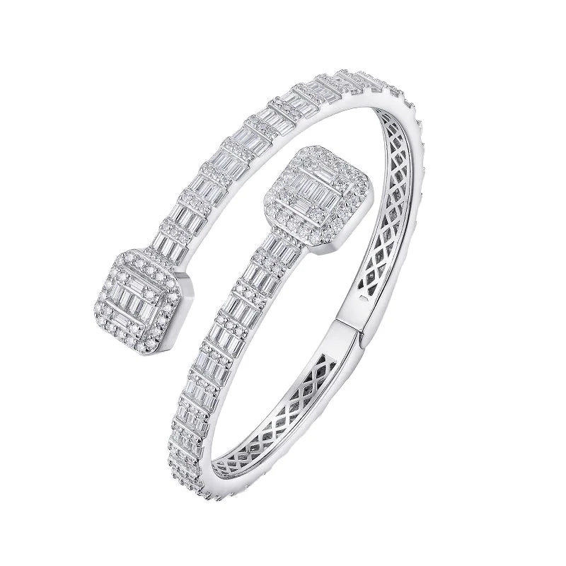 A silver-toned open cuff bangle bracelet adorned with multiple rows of baguette and round-cut clear stones, shown on a plain white background.