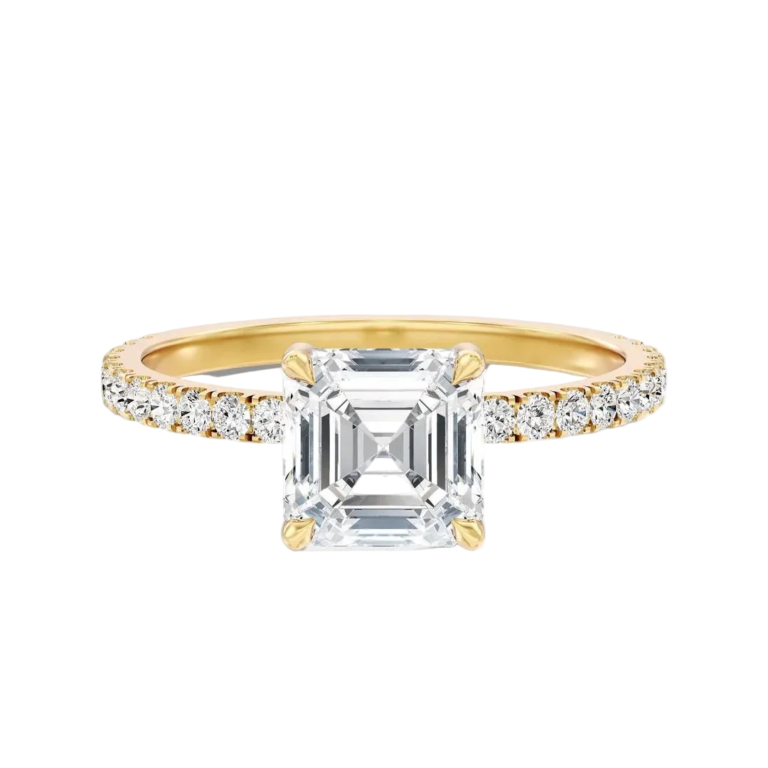 A yellow gold engagement ring featuring a large emerald-cut clear center stone and a pavé-set diamond band, shown on a clean white background.
