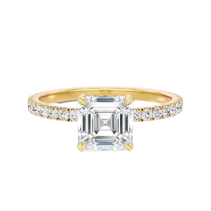 A yellow gold engagement ring featuring a large emerald-cut clear center stone and a pavé-set diamond band, shown on a clean white background.
